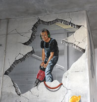 Anamorphic mural of a guy drilling into an elevator