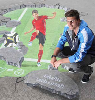 Mario Gomez poses with a 3D street painting of a football player